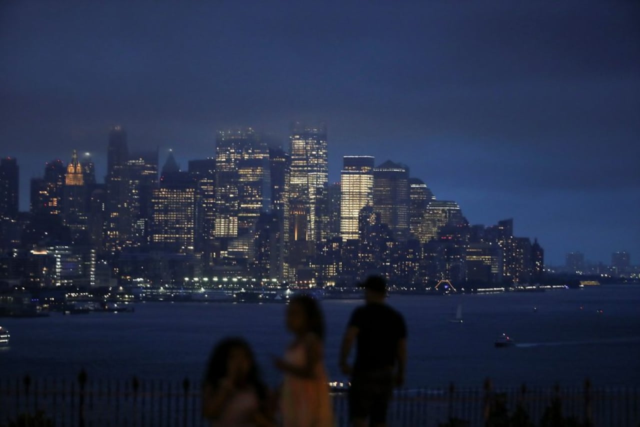 Personas observan cómo las nubes pasan sobre el centro de Manhattan y el Empire State Building mientras la tormenta tropical Henri atraviesa la ciudad de Nueva York. Foto: Reuters.